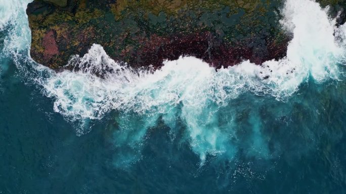 海浪飞溅的岩石海岸顶视图。惊人的泡沫冲浪撞击海滩