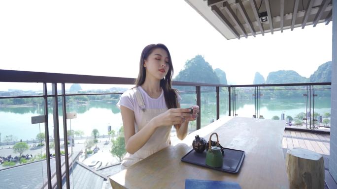 美女在江边住宅喝茶泡茶欣赏美景