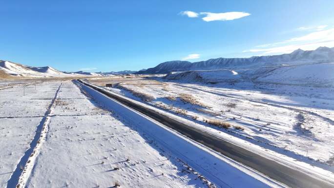 4k航拍汽车行驶在雪山脚下的公路上