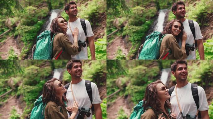 一对微笑的游客夫妇在山间瀑布前指手画脚