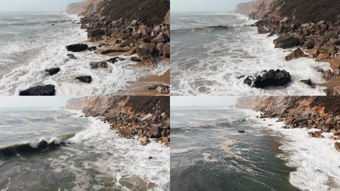 航拍镜头捕捉到海浪冲击葡萄牙纳扎雷崎岖海岸的不屈不挠的力量。海洋的不可驯服的力量展现出来。4 k。
