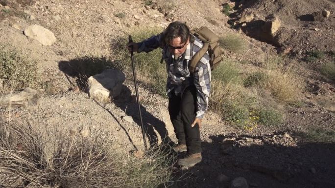 师兄在岩石区扭伤脚踝，碰伤腿。退休男子在沙漠地区徒步旅行