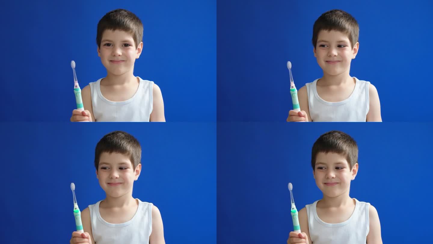 一个六岁的小男孩微笑着拿着一把电动超声波牙刷在蓝色色度键屏幕上。