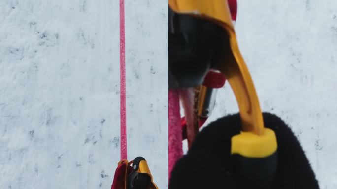 穿着冰爪的登山队员正在用固定绳索上的朱玛登山。垂直视频