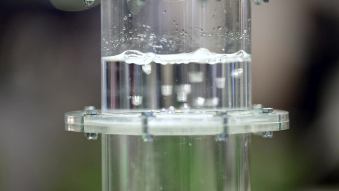 氢气在一个装满水的塑料瓶里通过膜冒着气泡，近距离看