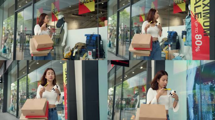 一个亚洲女人边走边吃冰淇淋到处都是购物袋。