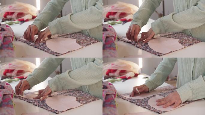 女设计师在印花织物上用纸图案做记号