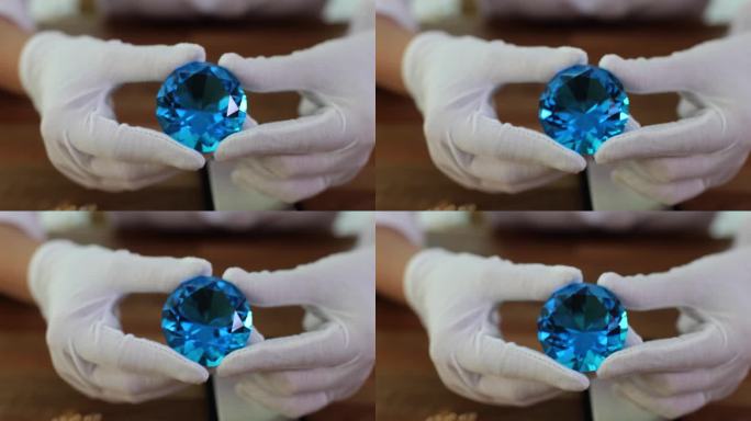 戴着白手套的珠宝商向客户展示蓝色水晶