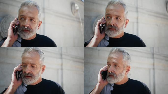 一个老人在度假时用智能手机说话。时尚长者休憩公园