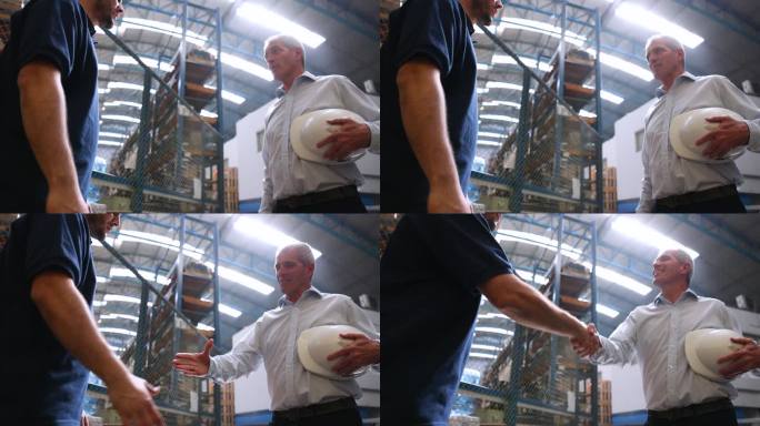 在工厂里，白人男性主管在提拔一名员工时非常愉快地握手