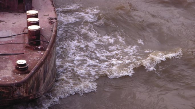 船的前部在塞纳河上逆流而上，波浪从船体上反弹的慢动作镜头。