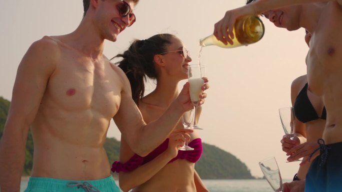 一群不同的朋友在游艇上开派对，喝着香槟。迷人的年轻男女聚在一起，庆祝节日，双体船在夏日夕阳下航行。