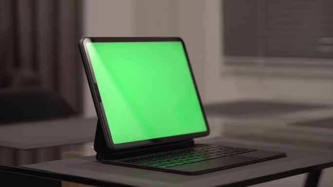 晚上坐在家里客厅的沙发上，iPad平板电脑的绿屏模型特写。色度关键技术，营销设计。