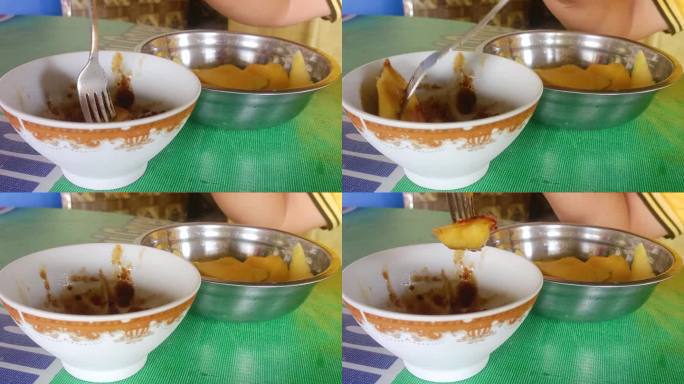 用叉子拿起蜜饯水果的手特写。