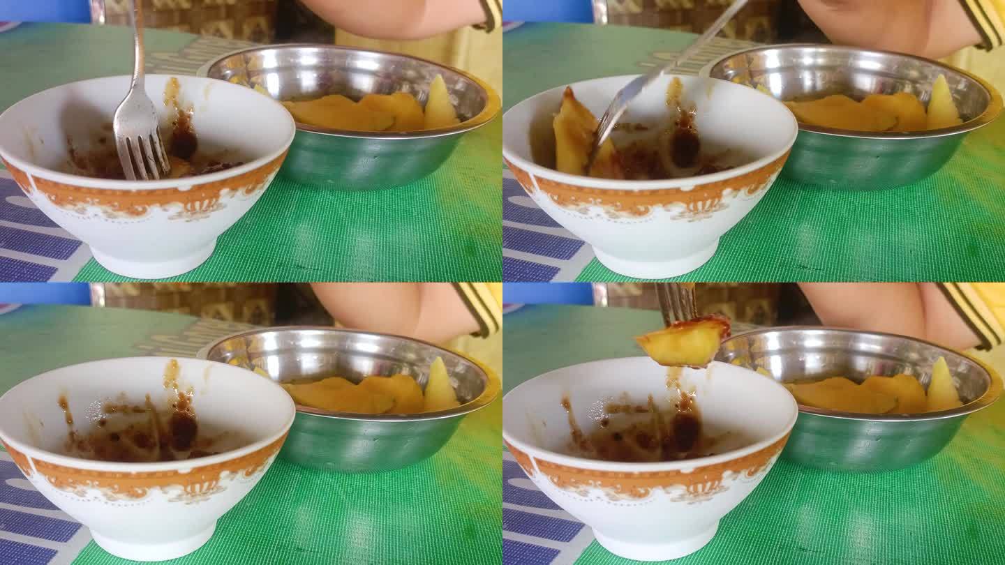 用叉子拿起蜜饯水果的手特写。