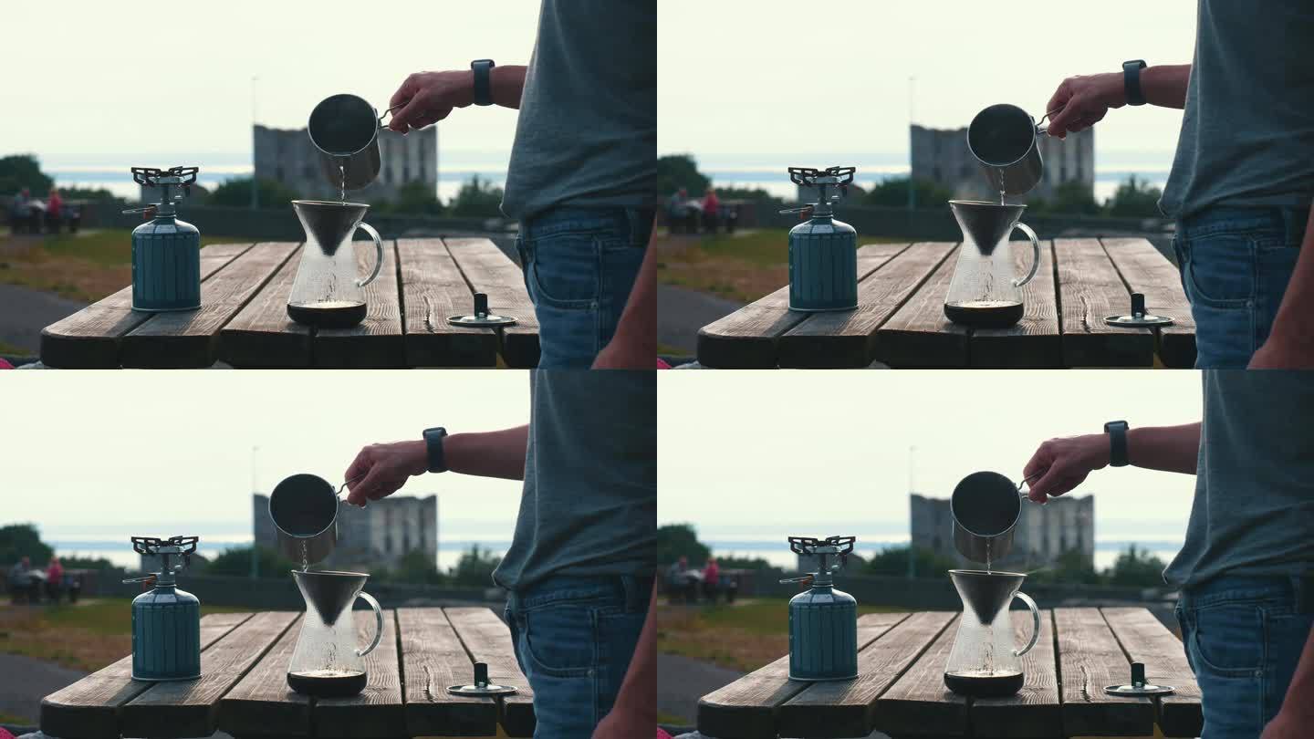 在露营环境中制作过滤咖啡，Сlose在玻璃咖啡机中倒入咖啡的水的镜头