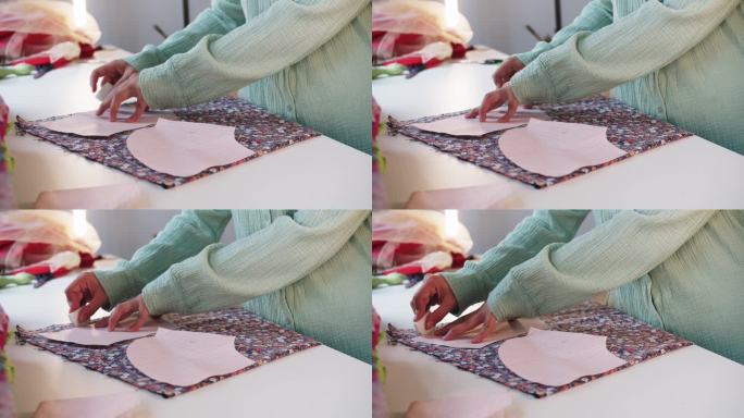 女设计师用纸图案在花织物上做记号