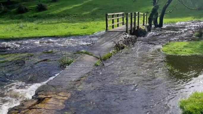 乡村石头被淹没的小路通往漫过洪水的木桥