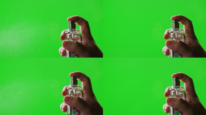 色度键绿色屏幕上，年轻人正在给皮肤喷香水，近距离喷香体奢侈香水。