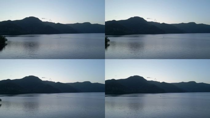 清晨的日出越过日本的群山，蓝天，小船回港。