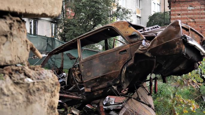 火灾或爆炸的后果
一辆被烧毁的汽车躺在雨中的建筑废墟中