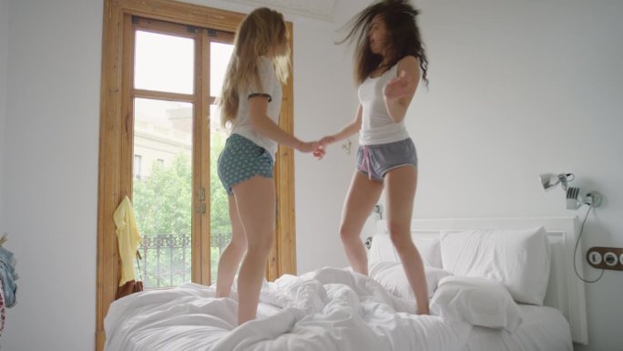 闺蜜们穿着睡衣在床上跳舞，分享在家里闲逛的时刻