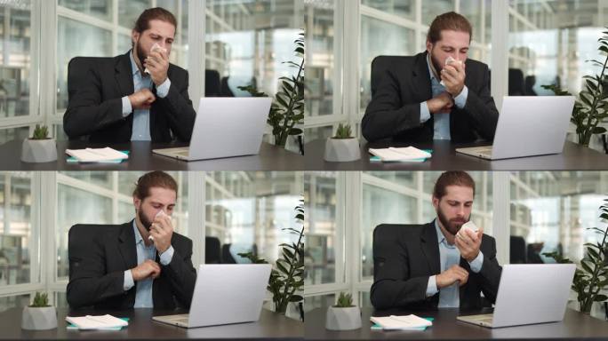 办公室里生病的帅哥一边咳嗽一边用纸巾擤鼻涕，一边用现代笔记本电脑坐在桌子旁。我是一个时髦的白人商人，