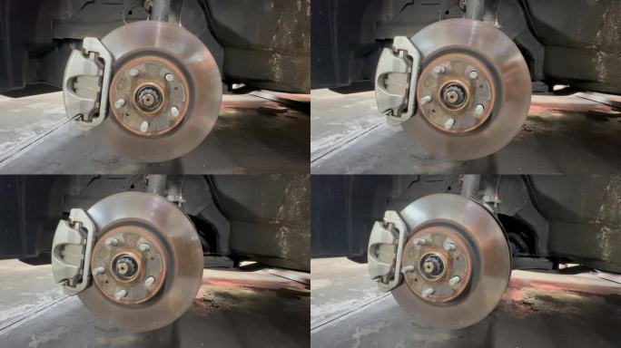 在汽车修理厂，人们把车轮从轮拱上拆下来修理汽车刹车