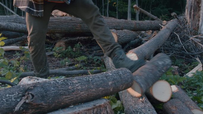 身强力壮的伐木工人穿着防护工作服，用链锯锯树枝
