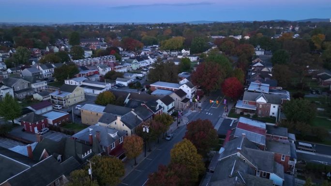 秋天日出时的美国小镇。主街的鸟瞰图，有房子和房屋，还有五颜六色的秋叶。