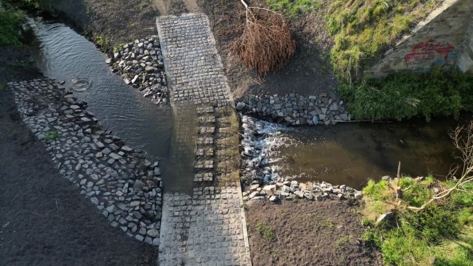 这条土路穿过一条小溪，这条小溪穿过河流，在洪水无法通行时继续前进。修复河道，将农田垂直排水改道