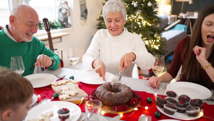 一个白种人家庭，在圣诞节午餐时吃面包蛋糕作为甜点