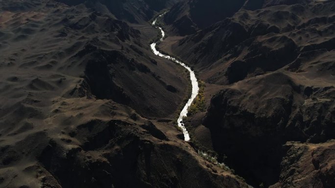 在阳光明媚的哈萨克斯坦山区，无人机在峡谷上方倾斜拍摄