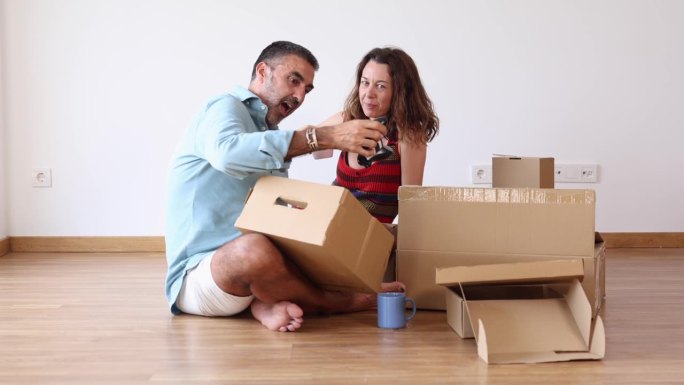 一对年轻的成年夫妇，最近搬家，在新家开始了新的生活，他们翻看着装着他们记忆的纸板箱