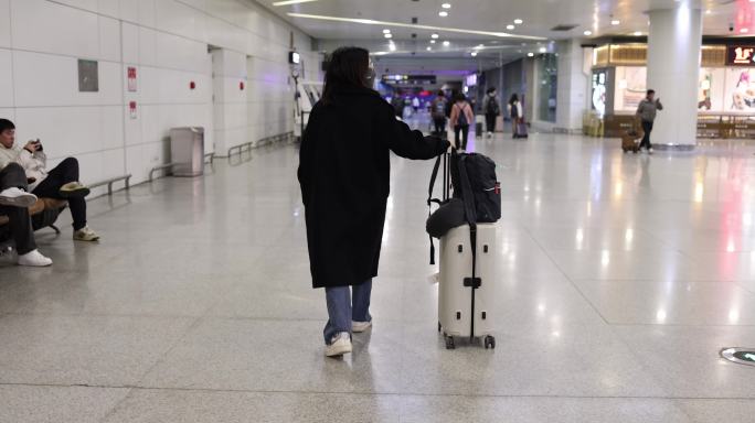 机场推着行李箱的旅客