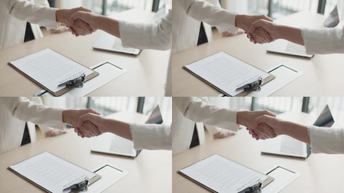 老板在办公室面试后与新员工握手的特写镜头。