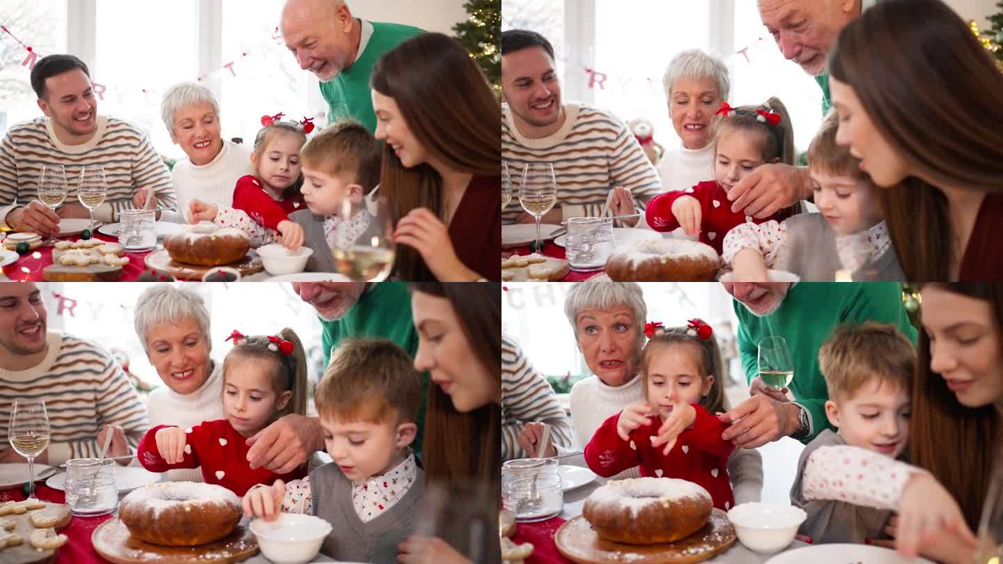 在家庭圣诞午餐期间，孩子们用蛋糕洒装饰蛋糕