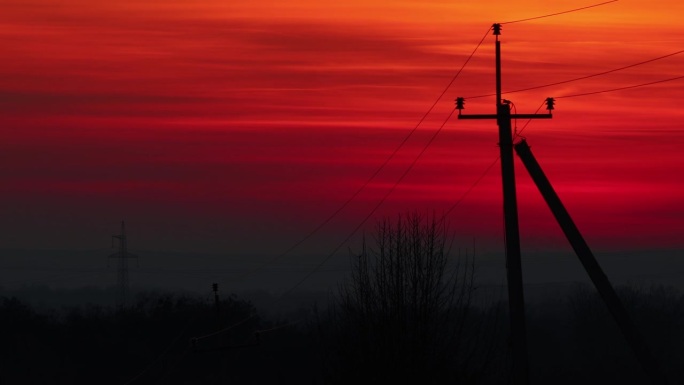 夕阳渐暗，乡村混凝土杆子上架起电线