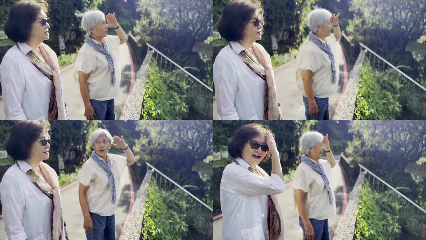 两个上了年纪的亚洲女人，是一辈子的朋友，在台湾九分观光，俯瞰着远处的城市和海景。