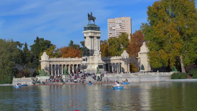 游船上的游客在马德里美丽公园的阿方索十二世纪念碑前