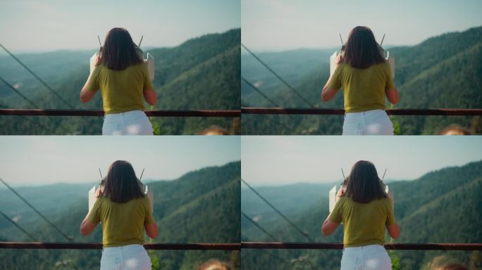 女人站在山顶上用双筒望远镜眺望