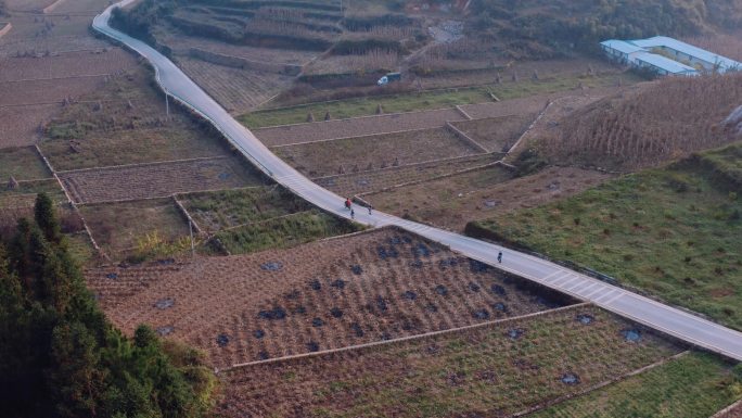 农民志愿者骑行在乡村公路