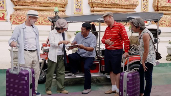 老年亚裔夫妇，老年高加索夫妇，是朋友，拖着大行李箱一起旅行清迈，他们在清迈地区分发嘟嘟车司机的app