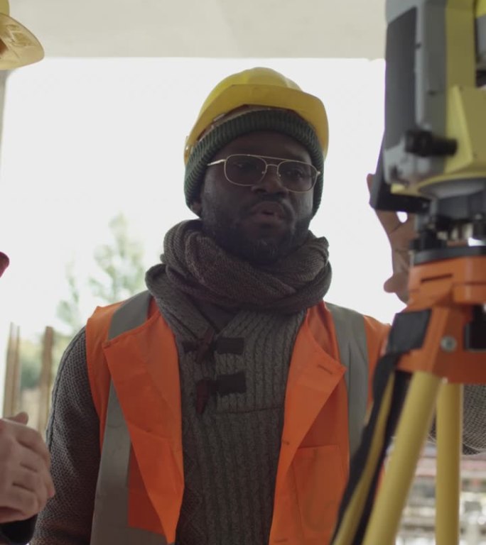 非裔美国工程师在建筑工地使用全站仪