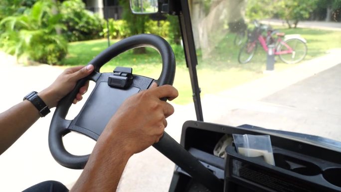 一名男子在度假胜地驾驶电动高尔夫球车