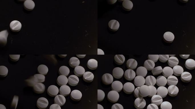 俯视图一堆白色药片散落在一个黑色的桌子上-阿片类药物危机