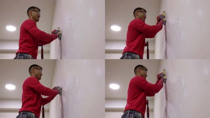 修理工在粉刷4k电影慢动作之前用刮刀打磨墙面