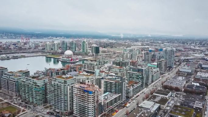 高角度无人机平移拍摄温哥华市。崭新的玻璃摩天大楼和科学世界