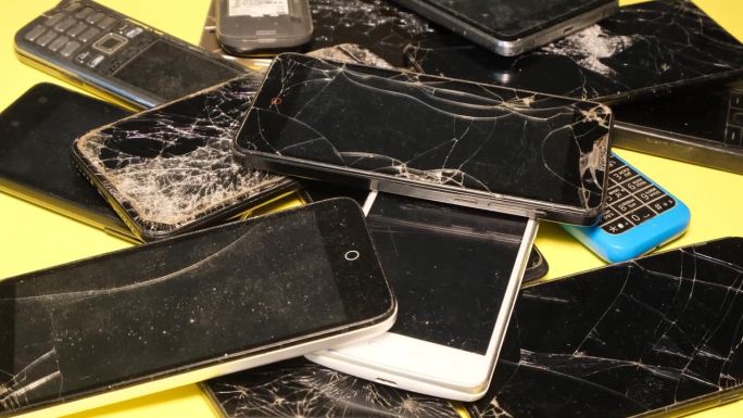 在一家维修店里，许多坏掉的智能手机。智能手机屏幕破碎