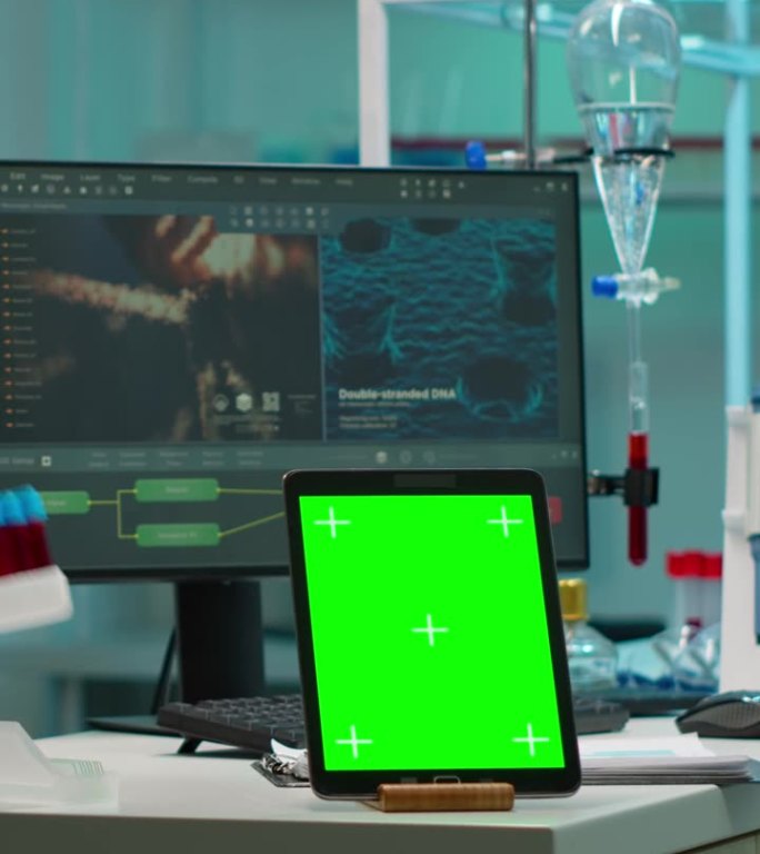 垂直视频:放置在实验室桌子上的绿色色度键屏平板电脑